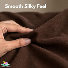 A close-up of a hand stretching and folding a smooth, dark brown fabric, with the text 'Smooth Silky Feel' at the top and a 'Happy Matty' logo in the bottom-left corner.